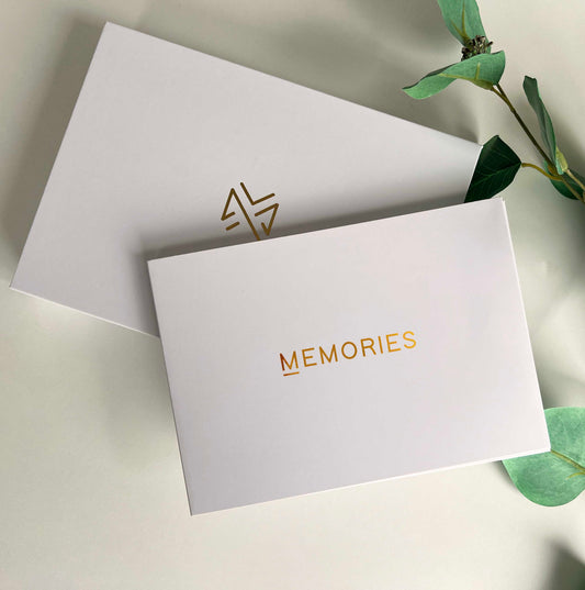 Memory Vault video book on the table with the box it comes in which has Memory Vault logo on it. This video book has Happy Birthday written on it gold colour